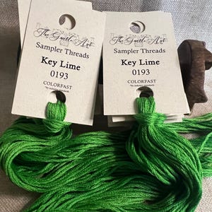 May include: Two spools of green embroidery floss labeled "The Gentle Art Sampler Threads Key Lime 0193 COLORFAST".