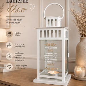Peut inclure: Une lanterne en métal blanc avec une anse et des parois en verre. La vitre avant porte l'inscription dorée : CETTE LUMIERE brille POUR CEUX QUI PARTAGENT AVEC NOUS CETTE SI BELLE JOURNEE DEPUIS LE paradis. Une bougie chauffe-plat est placée à l'intérieur.