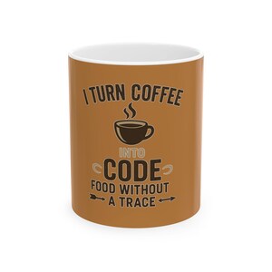 May include: A brown coffee mug with the text "I TURN COFFEE INTO CODE FOOD WITHOUT A TRACE" in a black, stylized font. A black coffee cup graphic is in the center. The mug has a white interior.