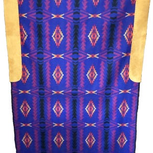 May include: A blue blanket with a geometric pattern of diamonds and zigzags in red, black, and white. The blanket has two tan leather patches on the sides. This blanket is suitable for home decor.