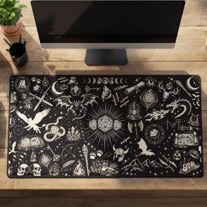 May include: A rectangular black desk mat featuring a detailed white line art pattern of fantasy elements including dragons, skulls, swords, d20 dice, moons, and various magical items spread across the entire surface of the mat.
