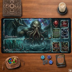 May include: A rectangular playmat featuring a large green tentacled creature, labeled sections for Battlefield, Lands, Command Zone, Exile, Library, Graveyard, and Life. Includes a wooden box, a candle, a drawstring pouch with glass marbles, and dice.