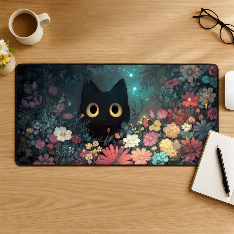 Puede incluir: Alfombrilla de rat&oacute;n rectangular con un gato negro de grandes ojos amarillos asomando desde un colorido jard&iacute;n de flores. Las flores son en tonos rosa, blanco, amarillo y azul, sobre un fondo oscuro.