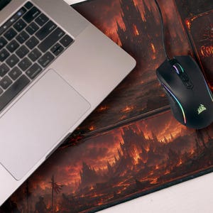 May include: A laptop and a black gaming mouse with rainbow LED lights sit on a large mousepad. The mousepad features a fiery fantasy landscape design with the words "Command Zone".