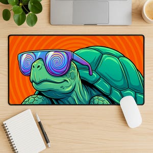 May include: A rectangular mouse pad featuring a cartoon turtle wearing sunglasses with a psychedelic design. The turtle is green with a detailed shell, set against an orange background with a spiral pattern. A white mouse and a laptop are also visible.