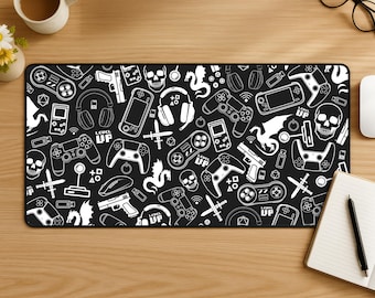 Puede incluir: Una alfombrilla de escritorio rectangular con fondo negro y un patrón gráfico blanco repetitivo de mandos de juego, consolas portátiles, calaveras, dragones, espadas, auriculares y el texto "LEVEL UP" por toda la superficie.