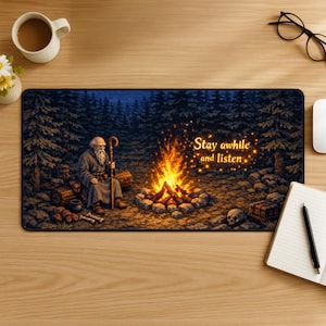 Puede incluir: Alfombrilla de rat&oacute;n rectangular con una ilustraci&oacute;n de un anciano con un bast&oacute;n junto a una fogata en un bosque. El texto "Stay awhile and listen" est&aacute; sobre el fuego. La paleta de colores incluye azules, verdes y naranjas.