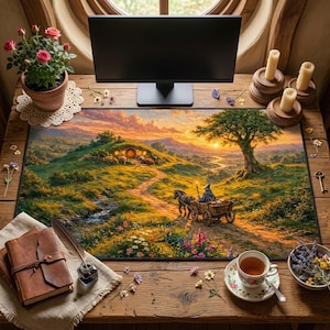 May include: A rectangular desk mat depicting a fantasy scene with a hobbit hole, a wizard in a cart, and a sunset. The mat is on a wooden desk with a monitor, candles, a teacup, and a potted plant. The color scheme includes greens, yellows, and oranges. The mat measures approximately 80 cm x 30 cm.