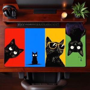 May include: A rectangular mousepad featuring four panels with black cat illustrations. The panels are red, blue, yellow, and green. One cat peeks from the corner, another is upright, one wears sunglasses, and the last is upside down.