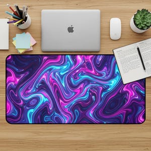 May include: A rectangular desk mat with a vibrant, swirling design in shades of purple, blue, and pink. The mat is placed on a wooden desk, alongside a laptop, mouse, and other office supplies.