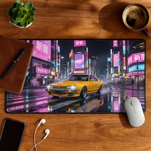 May include: A yellow sports car speeds across a crosswalk in a neon-lit cityscape, featured on a rectangular mousepad. The mousepad has a black border and a glossy surface. A brown leather notebook, pen, and a white mouse are also on the wooden surface.