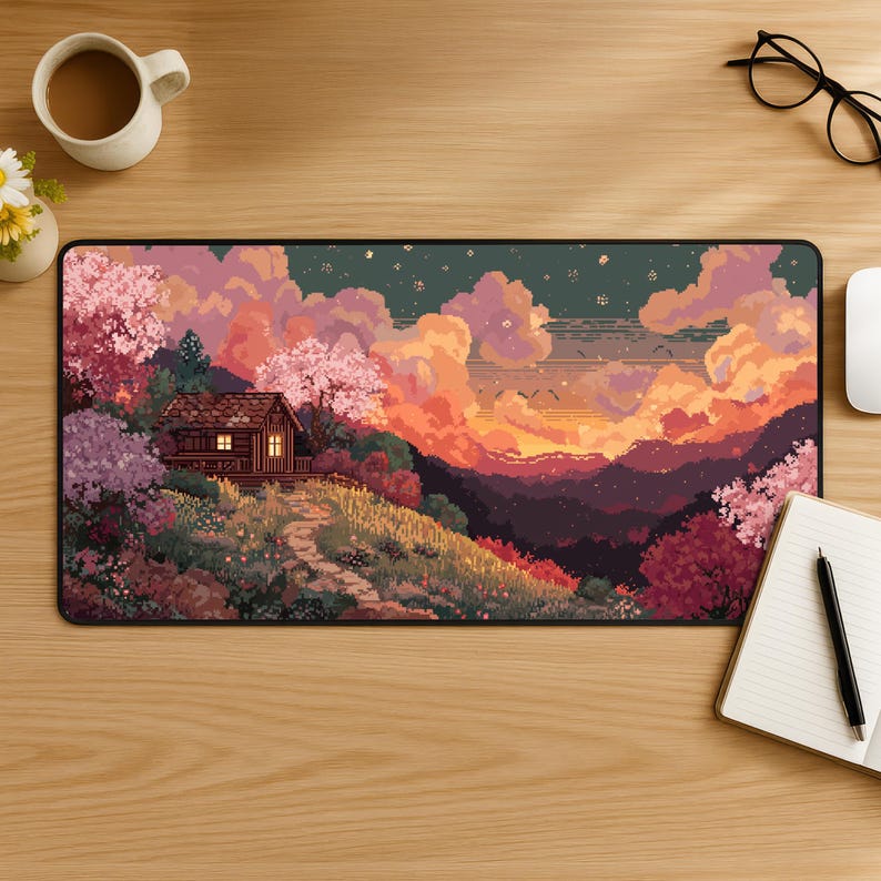 May include: A rectangular pixel art mousepad featuring a landscape with a cabin, trees, and a sunset. The color palette includes pink, orange, purple, and green hues. The mousepad is on a wooden desk with a cup of coffee and a notebook.