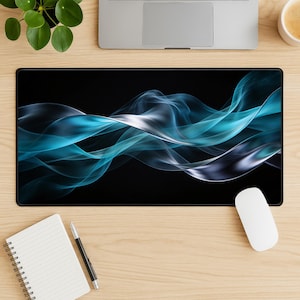 以下が含まれることがあります： 黒い長方形のマウスパッド。青と白の煙のような形が流れるようにデザインされています。マウスパッドは、ノートパソコン、白いマウス、メモ帳、ペン、小さな鉢植えの植物が置かれた木製の机の上にあります。