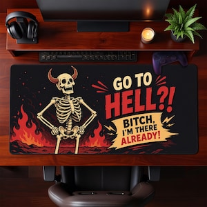 Pode incluir: Um tapete de secretária retangular preto com o gráfico de um esqueleto com chifres em frente a chamas vermelhas. O texto diz: GO TO HELL?! BITCH, I'M THERE ALREADY! O design utiliza uma paleta de cores vivas em vermelho, amarelo e branco.