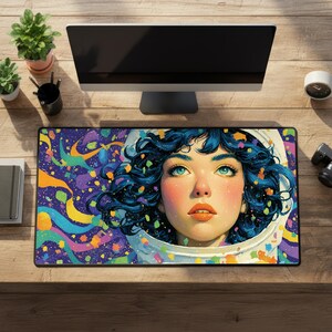 May include: A rectangular mousepad featuring a vibrant illustration of a woman with blue hair and eyes, wearing a space helmet. The background is a colorful swirl of purples, blues, greens, and yellows. The mousepad is on a wooden desk.