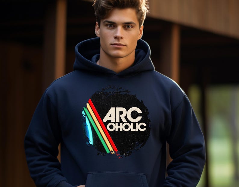Puede incluir: Una sudadera con capucha azul marino que presenta un gr&aacute;fico circular en el pecho. El dise&ntilde;o incluye el texto ARC OHOLIC en blanco, sobre un c&iacute;rculo negro desgastado con tres rayas diagonales en amarillo, verde y rojo a la izquierda.