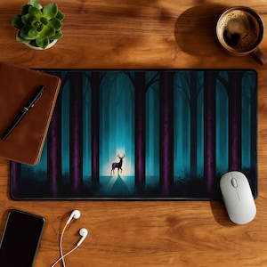 May include: A rectangular mousepad featuring a forest scene with tall, purple and black trees. A deer stands in a clearing with a bright light behind it. The mousepad is on a wooden desk with a coffee cup, succulent, and other items.