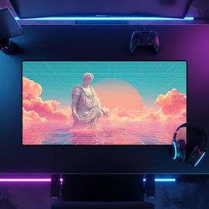 Pode incluir: Configuração de mesa de jogos preta com um monitor grande exibindo uma cena de arte digital de uma estátua clássica na água com um pôr do sol e nuvens. Um fone de ouvido e um controlador pretos também são visíveis.