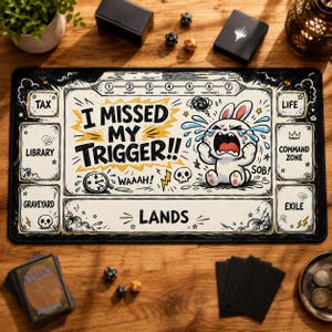 May include: A rectangular black and cream playmat featuring a cartoon rabbit crying with the text I MISSED MY TRIGGER!! WAAAH! and labeled zones for TAX, LIBRARY, GRAVEYARD, LANDS, LIFE, COMMAND ZONE, and EXILE, plus a turn sequence tracker.