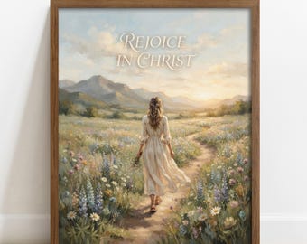 May include: A framed wall art print featuring a landscape painting of a person in a light-colored dress walking along a dirt path through a field of wildflowers toward distant mountains. The text "REJOICE IN CHRIST" is centered in the sky.