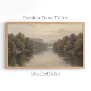 Könnte beinhalten: Ein Landschaftsgemälde in einem hellen Holzrahmen, das einen Fluss zwischen bewaldeten Ufern unter einem weichen, bewölkten Himmel zeigt. Der Text 'Premium Frame TV Art' und 'Little Pixel Gallery' steht über und unter dem Bild.