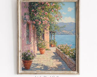 Pode incluir: Uma impressão de arte emoldurada retratando um terraço de pedra mediterrâneo ensolarado com vasos de terracota cheios de flores cor-de-rosa, rosas trepadeiras em uma parede rosa e uma vista para o mar azul com montanhas distantes.