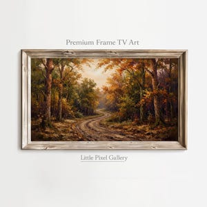 May include: A rectangular landscape painting in a weathered wooden frame depicting a winding dirt path through a dense forest with autumn foliage in shades of orange, yellow, and brown. The text Premium Frame TV Art and Little Pixel Gallery appear.