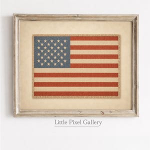 May include: Framed American flag art print. The flag features a blue canton with white stars and red and beige stripes. The print has a burlap texture and is set in a distressed, light-colored wooden frame. The text "Little Pixel Gallery" is at the bottom.