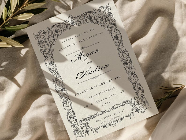 May include: Ivory wedding invitation with black ornate floral border. The invitation reads "Megan and Andrew" and includes the date August 16th, 2026. The RSVP information is also included. The invitation is on a cream-colored background.