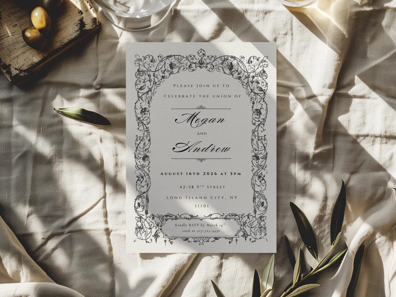 May include: A wedding invitation with an ornate floral border. The invitation features the names "Megan and Andrew" and the date "August 16th, 2026". The invitation is on a cream-colored paper, with the text in a dark gray color.