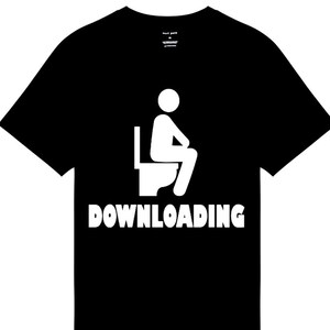 Può includere: T-shirt nera con grafica bianca di una persona seduta su un water. La parola "DOWNLOADING" è stampata in lettere bianche sotto. La maglietta ha un girocollo.