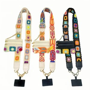 May include: Three colourful crossbody bag straps with small matching pouches. The straps feature embroidered floral and geometric patterns in various colours, including cream, orange, yellow, and black. Each strap has gold-coloured hardware and a black phone holder.