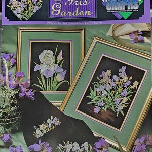 May include: A craft book titled "Iris Garden" featuring cross-stitch patterns of irises. The cover displays framed cross-stitch art with purple, white, and yellow irises. The book includes the text "Great Big Graphs" and "Easy Reading Counted Cross Stitch".