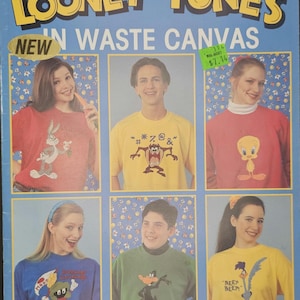 May include: A blue leaflet titled "LOONEY TUNES" featuring images of people wearing Looney Tunes character shirts. The leaflet includes the text "NEW IN WASTE CANVAS" and a Walmart price tag.