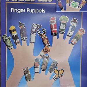 May include: Aida Plus Finger Puppets craft kit. The kit includes various finger puppets, including a witch, a skeleton, a Santa, a snowman, and a butterfly. The kit's packaging features the text "With Aida Plus you can cut, trim and shape - without fraying!"