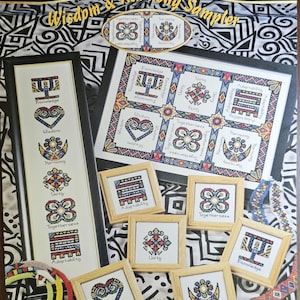 May include: A cross-stitch sampler pattern featuring a variety of colorful designs, including hearts, flowers, and geometric shapes. The pattern is titled "Wisdom & Harmony Sampler" and includes the dimensions 15.875 inches by 14.25 inches and 13.875 inches by 9.25 inches.