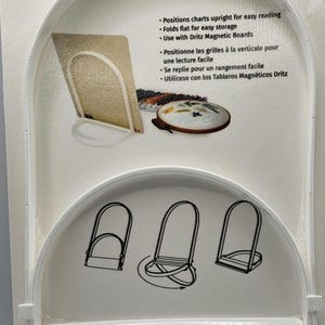 May include: White plastic folding stand for charts and magnetic boards. The packaging shows the stand in use, with text in English and French. The stand folds flat for easy storage.