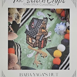 May include: A cross-stitch pattern titled "Baba Yaga's Hut" featuring a pixelated house with ghosts, bats, and a skull. The text "The Stitch Crypt, Cross Stitch Curiosities" is at the top. The design is on a green background with decorative elements.