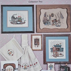 May include: A collection of cross-stitch patterns titled "Times Remembered" by Canterbury Designs. The image showcases framed cross-stitch samplers with various scenes, including a cat, a cozy interior, and kitchen accessories. The patterns include a welcome pineapple design.