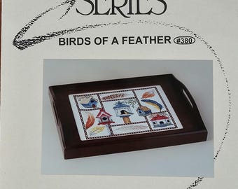 May include: A dark wood serving tray with a decorative tile insert featuring birdhouses and feathers. The tray is part of the "Designer Series" and is titled "Birds of a Feather". The tray has a rectangular shape with handles.