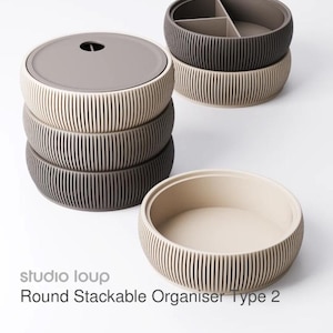 May include: Stackable round organizers in shades of beige, gray, and dark gray. The organizers have a ribbed exterior design and a lid with a small hole. One organizer has dividers. The text "Round Stackable Organizer Type 2" is visible.