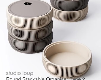 May include: A set of stackable, round organisers in beige, grey, and dark grey. They feature a ribbed exterior and a lid with a small hole. One organiser has dividers. The text reads "Round Stackable Organiser Type 2".