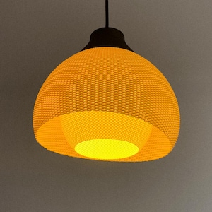 May include: A hanging pendant light with a woven, yellow lampshade. The light fixture has a dark brown top and a bright yellow interior. The light is suspended from a black cord against a gray background.