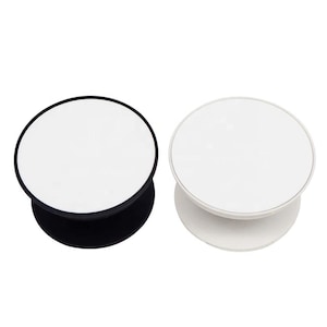May include: Two white circular phone grips with a collapsible base. One has a black border and base, the other a white border and base. These grips attach to the back of a phone for easier handling and use.