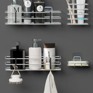 Puede incluir: Estanterías cromadas para baño fijadas a una pared gris, con varios artículos de aseo. Incluye botellas, tubos de pasta de dientes, cepillos de dientes, un jabonera, un paño y un cepillo. Diseñadas para organizar los elementos esenciales del baño.