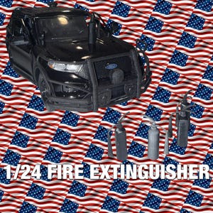 Op de afbeelding: Een zwart Ford politie-SUV-model met een beschermende voorbumper en drie miniatuur brandblussers. De afbeelding is geplaatst tegen een achtergrond van wapperende Amerikaanse vlaggen, met de tekst "1/24 FIRE EXTINGUISHER" onderaan.