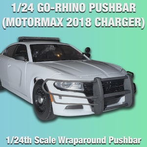 Op de afbeelding: Een wit 1/24 schaalmodel van een politieauto, een Dodge Charger, met een zwarte pushbar. De tekst op de afbeelding luidt "1/24 GO-RHINO PUSHBAR (MOTORMAX 2018 CHARGER)" en "1/24th Scale Wraparound Pushbar".
