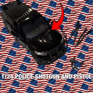 Op de afbeelding: Een zwart 1/24 schaal politieautomodel met een pushbar, ruitenwissers en extra zwarte speelgoedwapens. De achtergrond heeft een patroon van Amerikaanse vlaggen. De tekst "1/24 POLICE SHOTGUN AND PISTOL" staat onderaan.