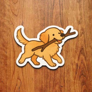 Op de afbeelding: Een sticker met een golden retriever die een bruine stok in zijn bek draagt. De cartoonhond heeft een witte rand en staat tegen een houten achtergrond. De hond is lichtbruin met donkerdere bruine accenten.