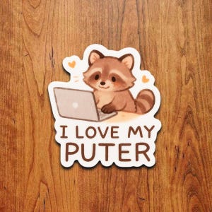 May include: A die-cut sticker featuring a cartoon raccoon sitting in front of a laptop. The raccoon is brown and tan with a striped tail. The text "I LOVE MY PUTER" is printed in brown below the raccoon.